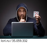 Young man wearing a hoodie sitting in front of a laptop computer. Стоковое фото, фотограф Elnur / Фотобанк Лори