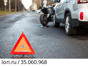 Warning triangle sign standing on a distance from road collision with motorbike and car. Стоковое фото, фотограф Кекяляйнен Андрей / Фотобанк Лори