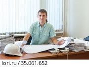 Architect or designer qualified in structural design working on the detailed project report in office, looking at camera. Стоковое фото, фотограф Кекяляйнен Андрей / Фотобанк Лори