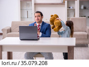 Girl bothering young father during working from house in pandemi. Стоковое фото, фотограф Elnur / Фотобанк Лори