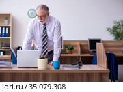 Old male employee suffering from radiculitis at workplace. Стоковое фото, фотограф Elnur / Фотобанк Лори
