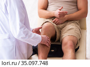 Experienced doctor traumatologist examining young male patient. Стоковое фото, фотограф Elnur / Фотобанк Лори
