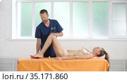 Positive male osteopath treating belly of patient. Стоковое видео, видеограф Гурьянов Андрей / Фотобанк Лори