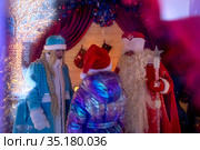 Дед Мороз и Снегурочка встречаются с детьми в резиденции Деда Мороза в парке на Речном вокзале в городе Москве, Россия (2021 год). Редакционное фото, фотограф Николай Винокуров / Фотобанк Лори