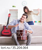 Young family singing and playing music at home. Стоковое фото, фотограф Elnur / Фотобанк Лори
