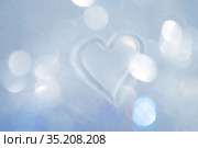 Hand-drawn heart on snowy surface with warm glittering bokeh background. Стоковое фото, фотограф Kira_Yan / Фотобанк Лори