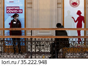 Люди стоят в очереди в мобильный пункт вакцинации от новой коронавирусной инфекции COVID-19 вакциной Спутник V в ГУМе города Москвы, Россия (2021 год). Редакционное фото, фотограф Николай Винокуров / Фотобанк Лори