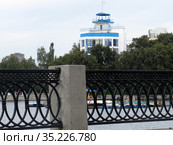 Россия. Екатеринбург. Набережная городского пруда, фрагмент ограды. Вдали здание-кораблик стадиона "Динамо" (2019 год). Стоковое фото, фотограф Владислав Сабанин / Фотобанк Лори
