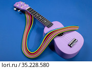 Четырехструнная гитара укулеле с абстрактной фигурой из цветной бумаги. Стоковое фото, фотограф V.Ivantsov / Фотобанк Лори