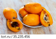 Closeup of whole ripe yellow loquat on wooden table. Vitamin fruits. Стоковое фото, фотограф Яков Филимонов / Фотобанк Лори
