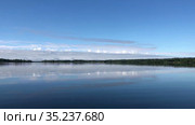 Moving on surface of large calm forest lake. Blue sky reflecting in water. Karelia, Russia. Стоковое видео, видеограф Кекяляйнен Андрей / Фотобанк Лори