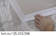 Installation of a ceiling skirting board on liquid nails to a ceiling, a wall. Стоковое видео, видеограф Константин Мерцалов / Фотобанк Лори