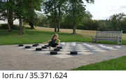Little girl is playing large outside checkers in the park. Active child, happy childhood concepts. Стоковое видео, видеограф Ольга Балынская / Фотобанк Лори