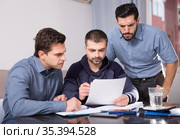 Three men worriedly discussing documents. Стоковое фото, фотограф Яков Филимонов / Фотобанк Лори