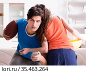 Man watching americal football with his wife. Стоковое фото, фотограф Elnur / Фотобанк Лори