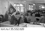 Рабочий цеха по сортировки слюды на горнодобывающем предприятии, множество девушек находится в просторном помещении с лампочками накаливания под потолком, Эмельджак, Якутия, 1961. Редакционное фото, фотограф Варфоломей Тетерин / Фотобанк Лори