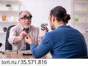 Young man visiting old male jeweler. Стоковое фото, фотограф Elnur / Фотобанк Лори