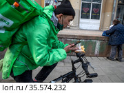 Курьер сервиса доставки еды Delivery Club доставляет заказ в центре города Москвы, Россия (2021 год). Редакционное фото, фотограф Николай Винокуров / Фотобанк Лори