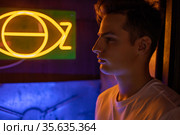 Portrait of attractive young man in neon lighting. Стоковое фото, фотограф Женя Канашкин / Фотобанк Лори