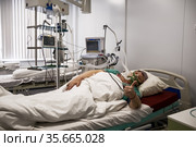 Женщина, больная КОВИД-19 подключена к аппарату ИВЛ, в реанимационной палате интенсивной терапии инфекционного отделения больницы. Богучаны, Красноярский край, Россия (2021 год). Редакционное фото, фотограф Светлана Попова / Фотобанк Лори