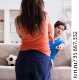 Wife unhappy that husband is watching football. Стоковое фото, фотограф Elnur / Фотобанк Лори