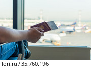 Closeup of male holding passports and boarding pass at airport. Стоковое фото, фотограф Константин Лабунский / Фотобанк Лори