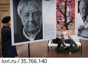Женщина смотрит фотовыставку  Юрия Роста в ГУМе. Москва, режиссер Юрий Любимов (2021 год). Редакционное фото, фотограф Дмитрий Неумоин / Фотобанк Лори