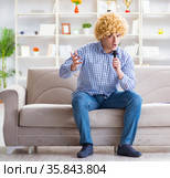 Funny man singing songs in karaoke at home. Стоковое фото, фотограф Elnur / Фотобанк Лори