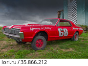 Красный ретро втомобиль Mercury Cougar GT-Е (1968) на фоне сумрачного неба. Международный фестиваль ретро транспорта "Фортуна-2016", Кронштад. Редакционное фото, фотограф Виктор Карасев / Фотобанк Лори
