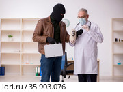 Masked man burglar bribing old doctor for getting vaccine. Стоковое фото, фотограф Elnur / Фотобанк Лори