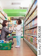 Mother and Daughter Playing in the Supermarket. Стоковое фото, агентство Ingram Publishing / Фотобанк Лори