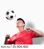 Footballer heading the ball, white background. Стоковое фото, агентство Ingram Publishing / Фотобанк Лори