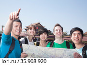 Five people looking at map with Tiananmen Square in background. Стоковое фото, агентство Ingram Publishing / Фотобанк Лори