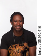 Portrait of young man with dreads smiling, studio shot. Стоковое фото, агентство Ingram Publishing / Фотобанк Лори