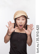 Portrait of surprised woman with hands raised, studio shot. Стоковое фото, агентство Ingram Publishing / Фотобанк Лори