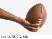 Man holding American football. Стоковое фото, фотограф Shannon Fagan / Ingram Publishing / Фотобанк Лори
