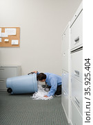 Man looking a shredded paper bin. Стоковое фото, фотограф Shannon Fagan / Ingram Publishing / Фотобанк Лори