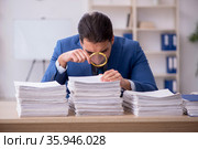 Young male employee unhappy with excessive work in the office. Стоковое фото, фотограф Elnur / Фотобанк Лори