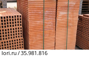 Pallets with stack of redbricks lying at warehouse of building materials in sunny day. Стоковое видео, видеограф Яков Филимонов / Фотобанк Лори