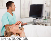 doctor conducting ultrasound examination of patient's thyroid lying. Стоковое фото, фотограф Яков Филимонов / Фотобанк Лори