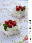 Pavlova cake with strawberries with a cup of cappuccino on a colorful napkin. Стоковое фото, фотограф Tetiana Chugunova / Фотобанк Лори