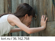 Девочка подсматривает в замочную скважину. Стоковое фото, фотограф WalDeMarus / Фотобанк Лори
