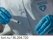 Медсестра готовит шприц к уколу в медицинском кабинете городской московской поликлиники (2021 год). Редакционное фото, фотограф Николай Винокуров / Фотобанк Лори