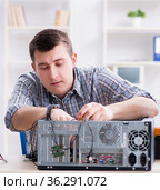 Young technician repairing computer in workshop. Стоковое фото, фотограф Elnur / Фотобанк Лори