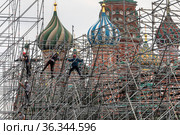 Рабочие собирают леса для сцены на Красной площади в центре города Москвы на фоне храма Василия Блаженного (2021 год). Редакционное фото, фотограф Николай Винокуров / Фотобанк Лори