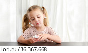 Kid playing with TWS earbuds white background. Стоковое фото, фотограф Ekaterina Demidova / Фотобанк Лори