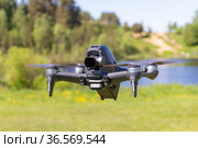Moscow, 31 MAY 2021 : A new DJI FPV drone is flying during a sunny day on grass in beckground. Top Front View. Headless Quadcopter with Digital 4K 60 fps Hasselblad Camera and Remote Control. Стоковое фото, фотограф Алексей Ширманов / Фотобанк Лори