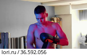 Shirtless young man boxer putting boxer gloves in blue and red neon lighting. Стоковое видео, видеограф Константин Шишкин / Фотобанк Лори