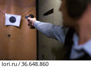 Male arm with smallbore sporting pistol aiming at bullseye target. Стоковое фото, фотограф Яков Филимонов / Фотобанк Лори