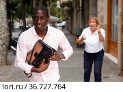 Street thief running away after stealing handbag from woman. Стоковое фото, фотограф Яков Филимонов / Фотобанк Лори